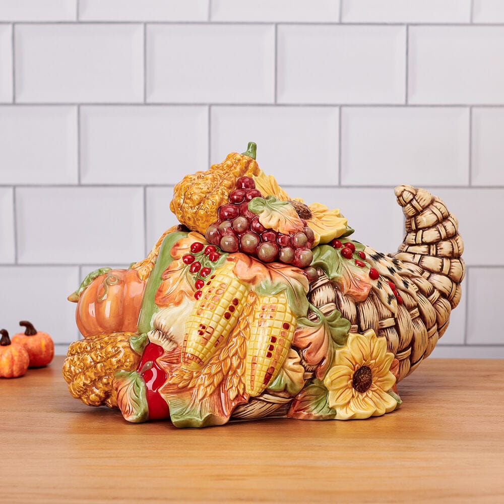 Cornucopia cookie jar with pumpkins, corn, grapes and sunflowers on a kitchen counter