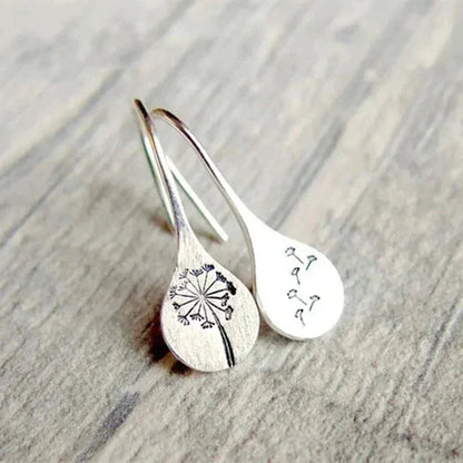Close-up of women's sterling silver dandelion teardrop dangle earrings. Delicate unique design with real dandelion seeds.